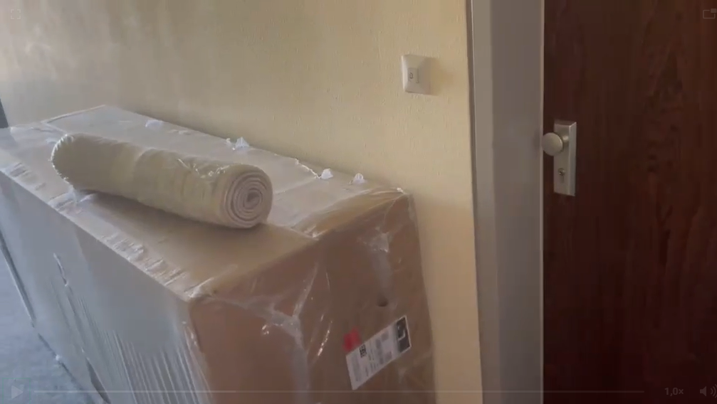 Verpackte Kartons und gerollter Topper in der Wohnung